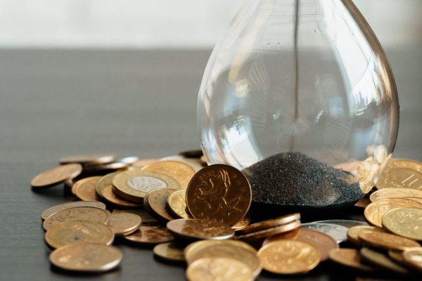 time-is-money-close-up-of-hourglass-with-money-co-2023-11-27-05-06-24-utc